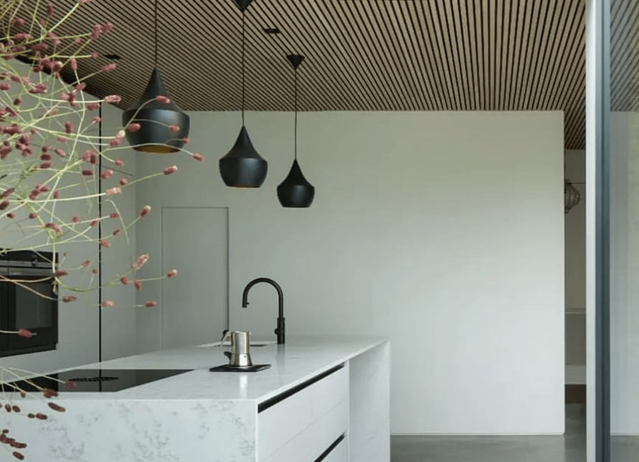 image of a kitchen with a white island, Slatwall ceiling and black ceiling lights