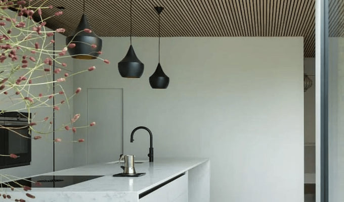 image of a kitchen with a white island, Slatwall ceiling and black ceiling lights