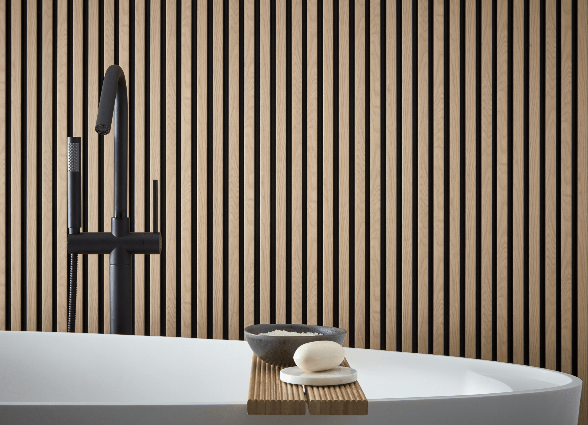 Bathroom interior design featuring SlatWall Waterproof Natural oak and Black behind a white bathtub.