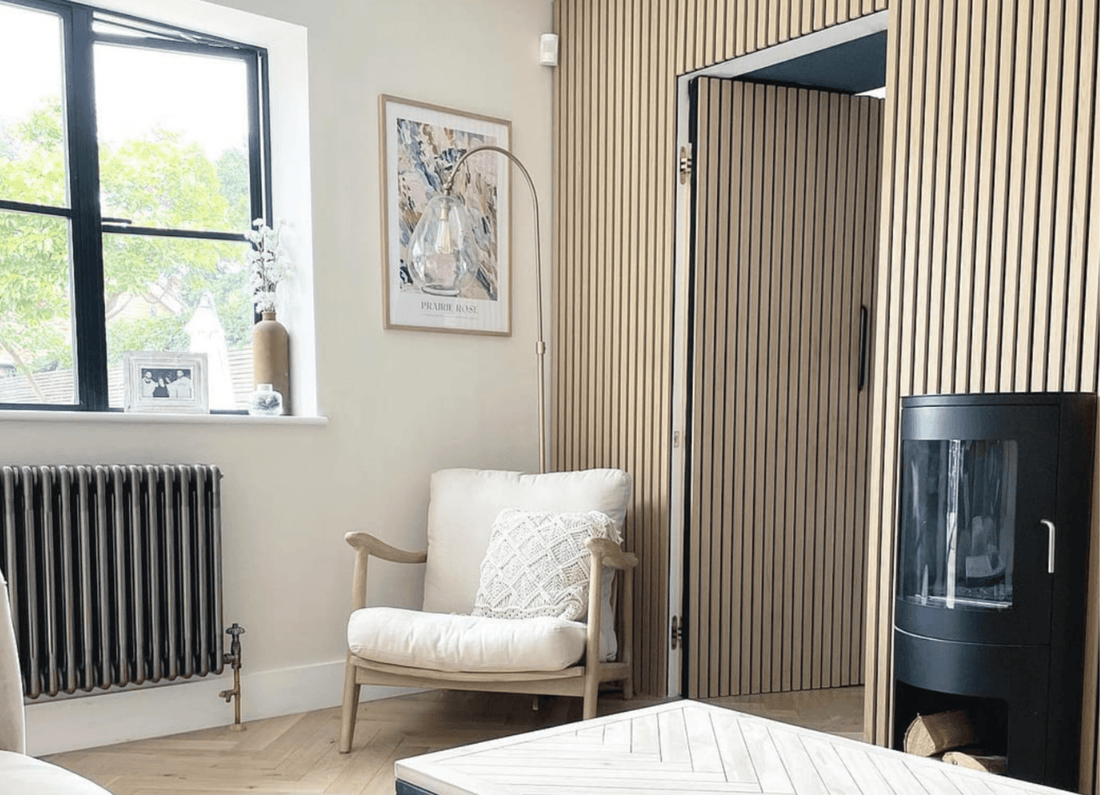 Armchair and fireplace next to hidden door made from SlatWall Washed Oak panels