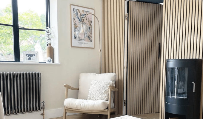 Armchair and fireplace next to hidden door made from SlatWall Washed Oak panels