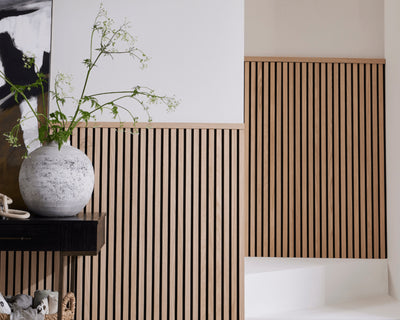 A hallway and staircase featuring half-wall panelling made with SlatWall Midi and a Top Trim in Natural Oak.