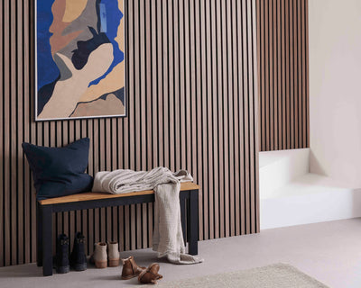 Hallway wall decorating idea featuring SlatWall Walnut wood veneer panels, a blue and beige painting and matching bench.