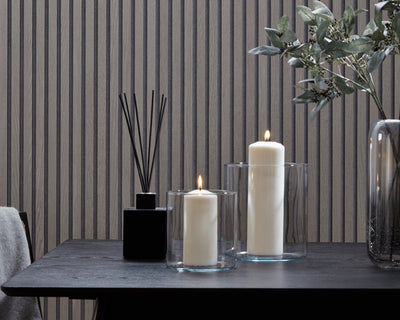 Greige interior design featuring SlatWall Grey Oak panels and a black table with two lit candles, a reed diffuser and vase