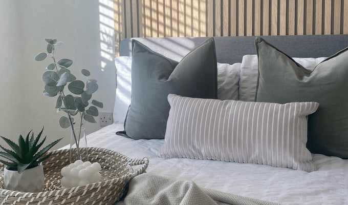 Scandi trends through slatwall panels as a feature wall and neutral colours scheme across bedding on bed in front..