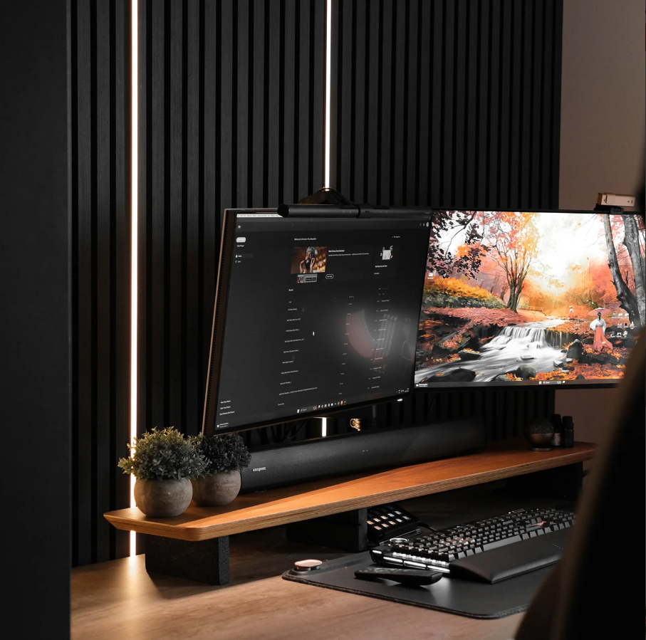 Desk set up with black acoustic wall panelling with two monitors.