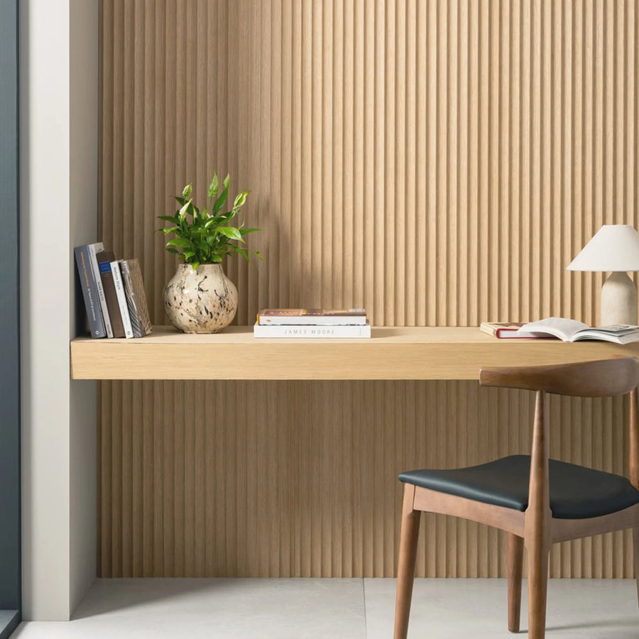 Modern home office with wooden desk, chair, and decorative elements. Fluted Arborelle wall panelling on the wall