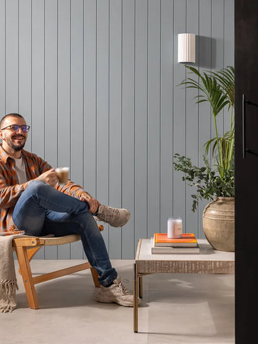 image of persona sat in front of mdf panelling having a cup of team 