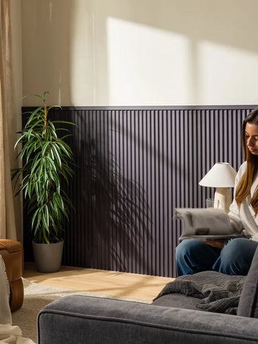 image of person sat on sofa reading a magazine in front of half height mdf panelling in living room 
