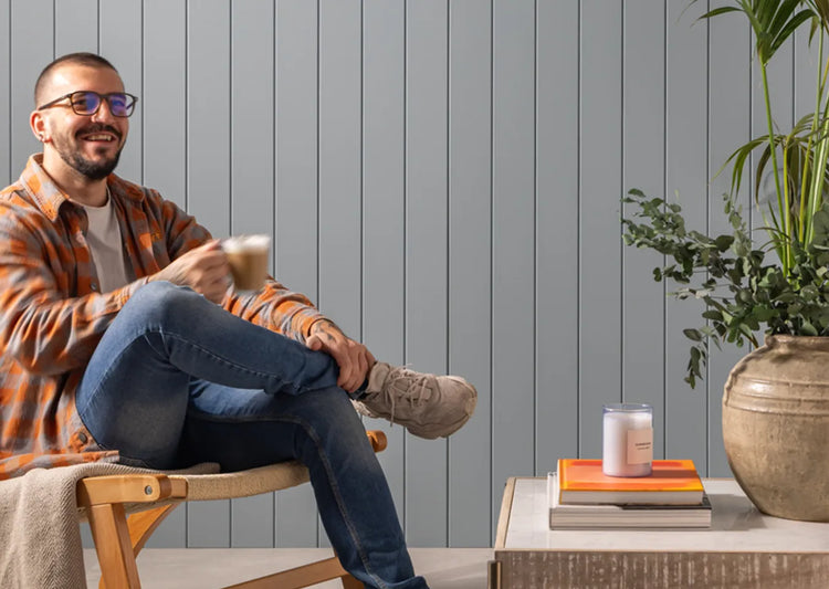 image of person sat infront of mdf panelling with a cup of coffee 