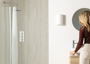 image of person in bathroom next to white wall and shower panels 