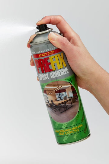 Hand hold contact spray adhesive can without lid. Spraying the adhesive.