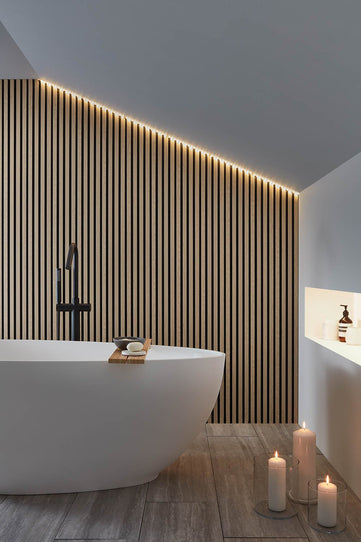Bathroom set showing Oak and Black SlatWall Waterproof on bathroom wall with contemporary white bath in foreground.

