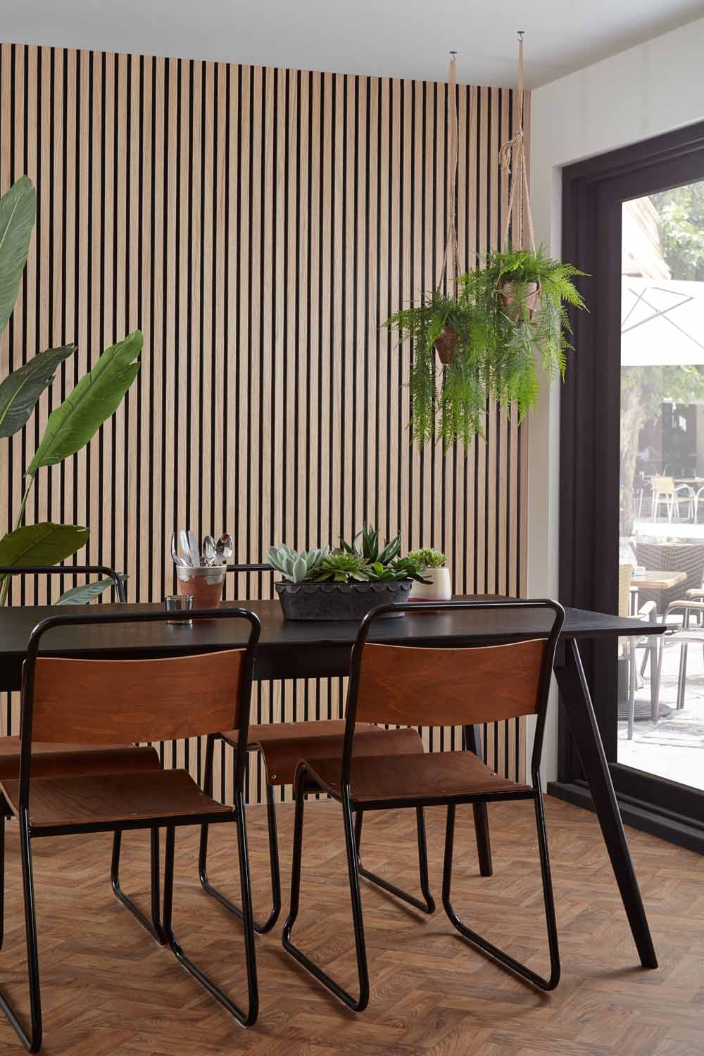 Natural Oak and Black Acoustic SlatWall Panels from Naturewall in a dining room setting. 

