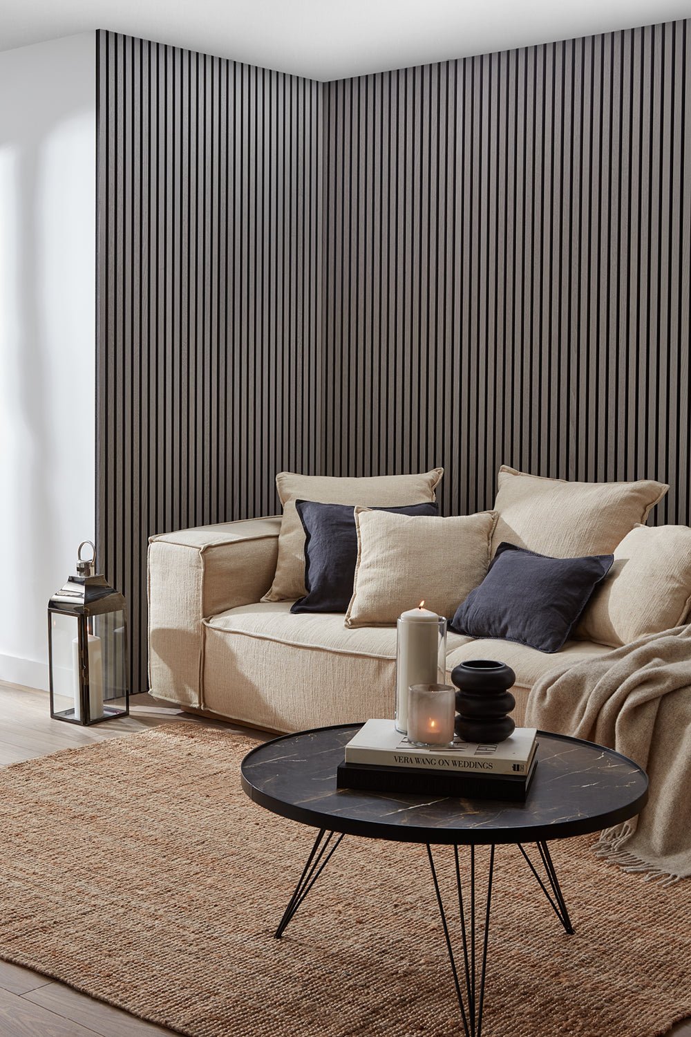 Grey Oak Acoustic SlatWall Panels from Naturewall in a living room setting, behind sofa and coffee table.