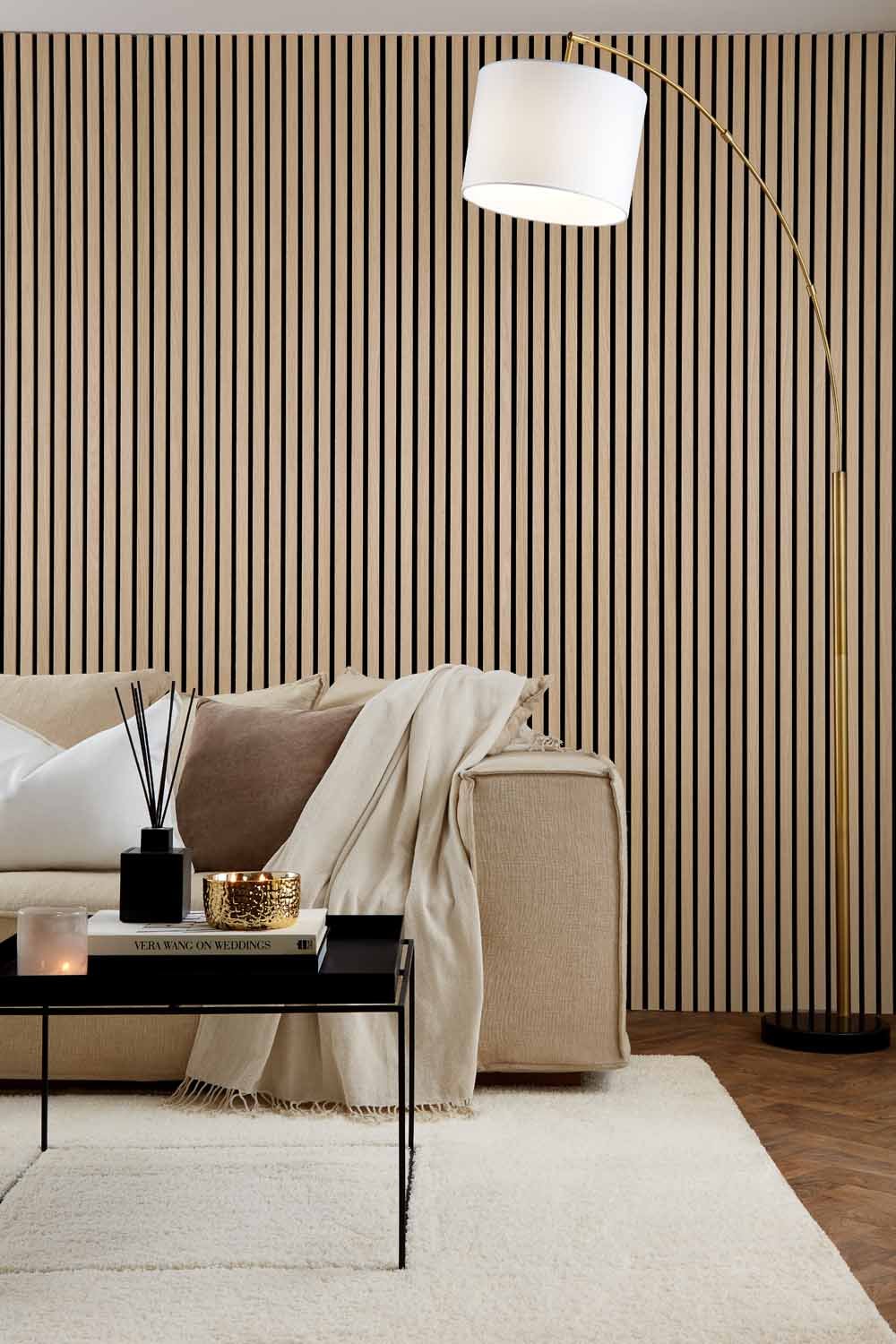 Natural Oak Acoustic SlatWall Panels from Naturewall in a modern living room setting, behind sofa and coffee table.

