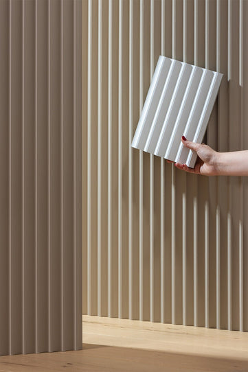 close up image of a primed fluted panel next to the product 

