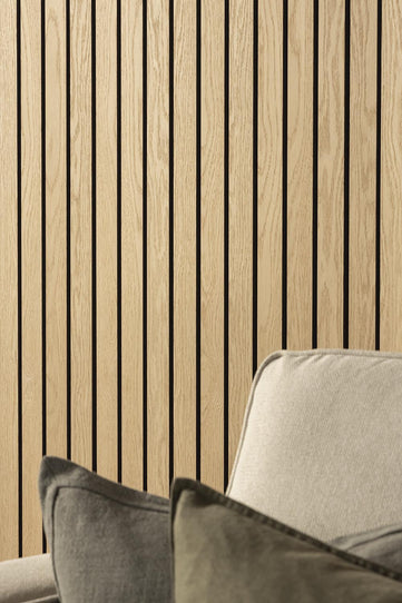 Natural Oak SlatWall Grand Panels from Naturewall behind a sofa in a living room.

