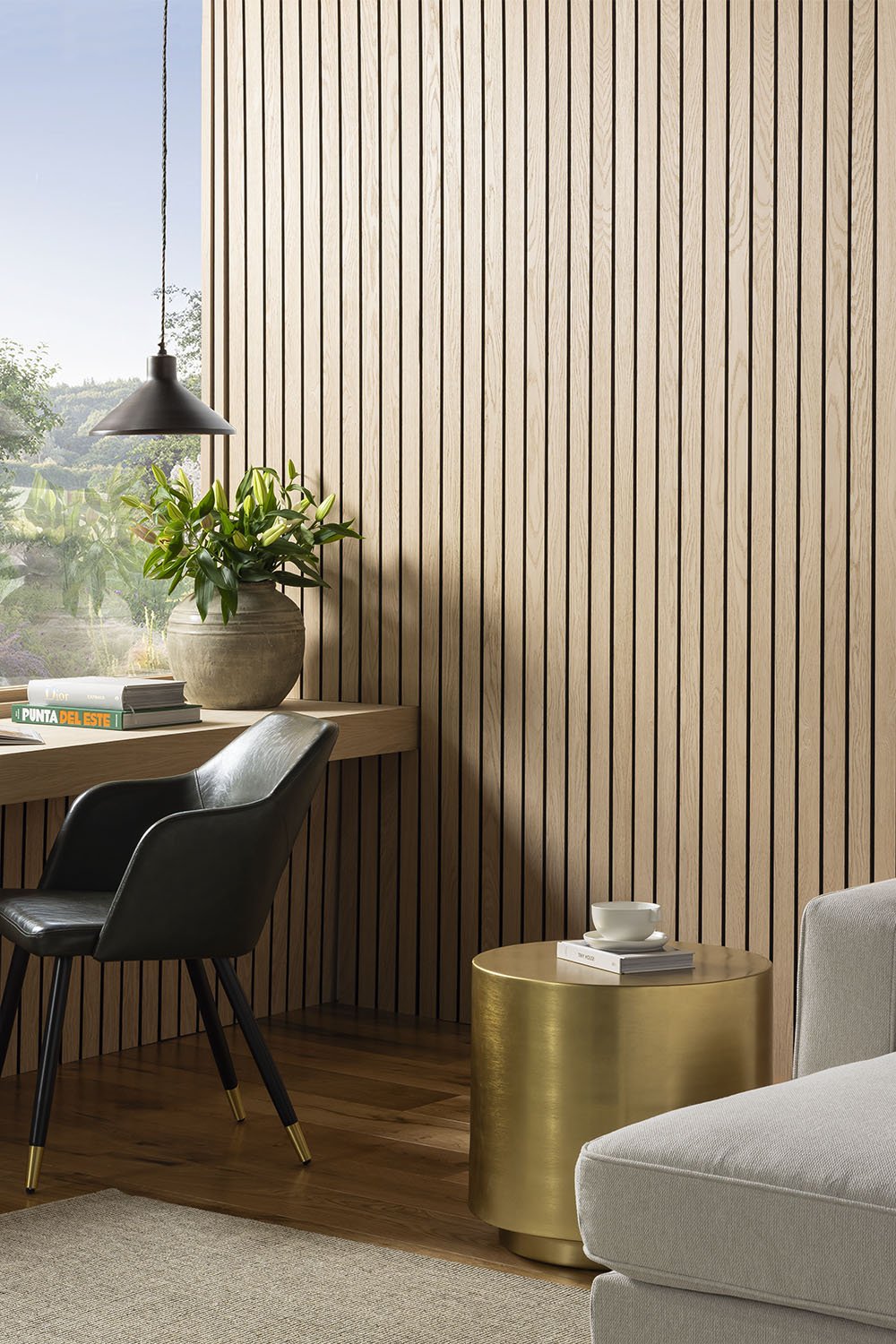 Natural Oak SlatWall Grand Panels from Naturewall across a modern living room setting, behind sofa and coffee table in day time setting.

